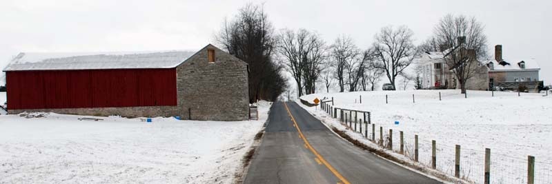 The Jacob Spears house is shown here on the right side of Clay-Kiser Road. On the left is the stone storage barn for whiskey. Courtesy of Hopewell Museum.